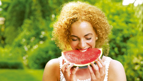 Frau beißt in eine Melone