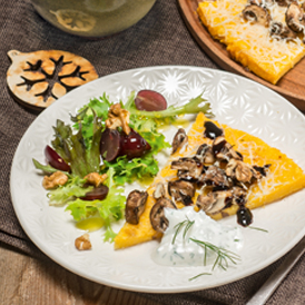 Überbackene Polenta-Parmesan-Ecken an fruchtigem Blattsalat